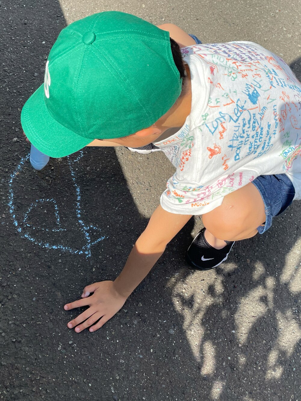 ホワイト系のTシャツ/カットソー、ブルー系のデニムパンツ、ブラック系のスニーカーを着用したキッズの夏コーディネートの3枚目の写真