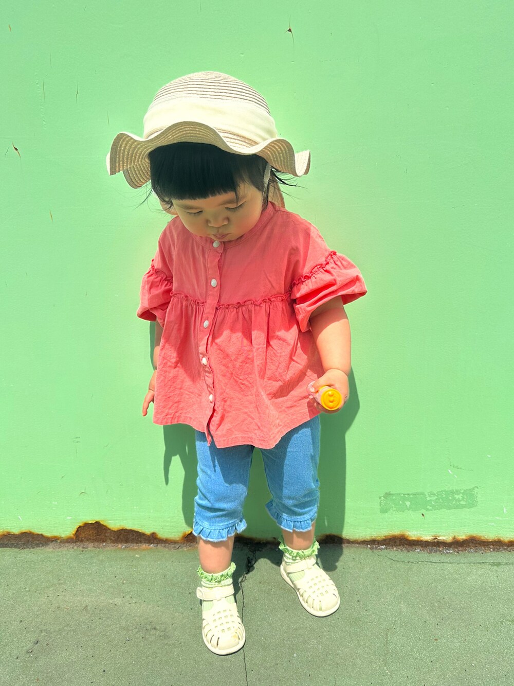 ピンク系のシャツ/ブラウス、ホワイト系のサンダル、ベージュ系のハットを着用したキッズの春コーディネートの2枚目の写真