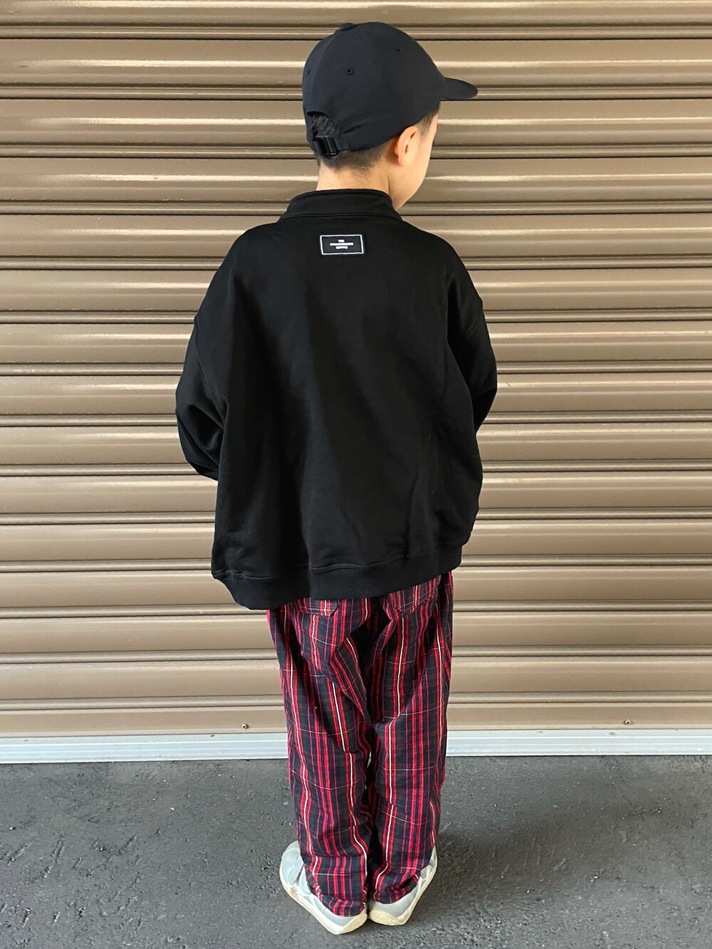 ブラック系のスウェット、レッド系のその他パンツ、シルバー系のスニーカーを着用したキッズの秋コーディネートの4枚目の写真