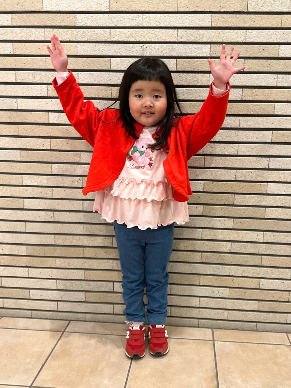 ピンク系のTシャツ/カットソー、レッド系のスニーカー、レッド系のカーディガン/ボレロを着用したキッズの春コーディネートの3枚目の写真