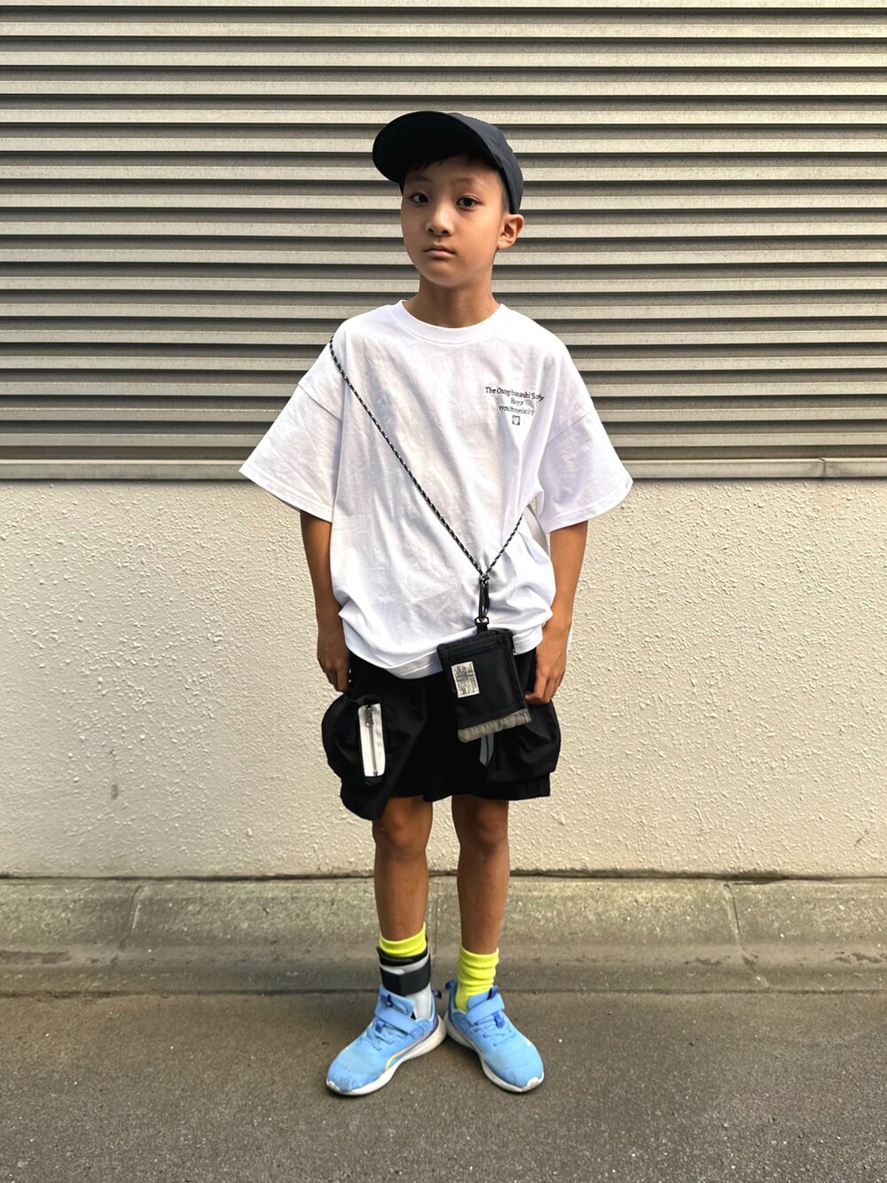 ブルー系のスニーカー、ホワイト系のTシャツ/カットソー、ブラック系のパンツを着用したキッズの夏コーディネートの2枚目の写真