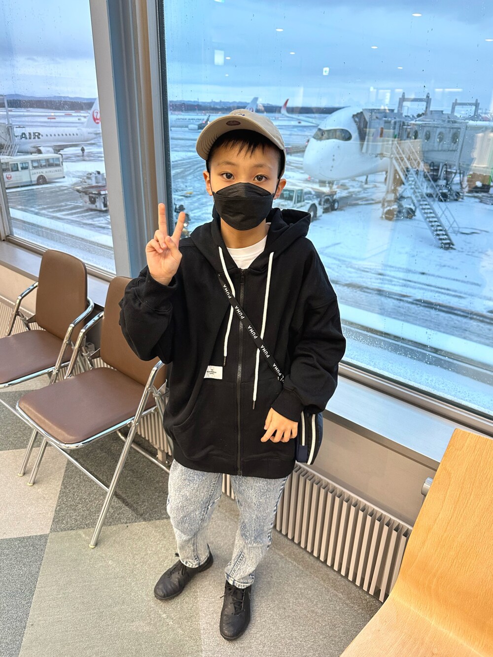 ブラック系のパーカー、その他のデニムパンツ、ブラック系のスニーカーを着用したキッズの春コーディネートの4枚目の写真