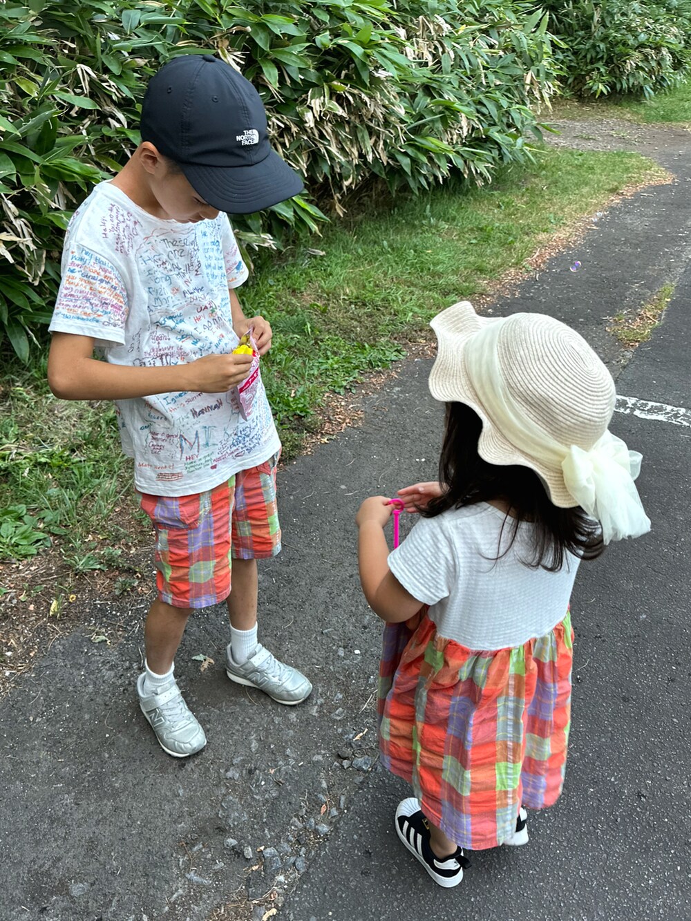 ホワイト系のTシャツ/カットソー、オレンジ系のパンツ、シルバー系のスニーカーを着用したキッズの夏コーディネートの3枚目の写真