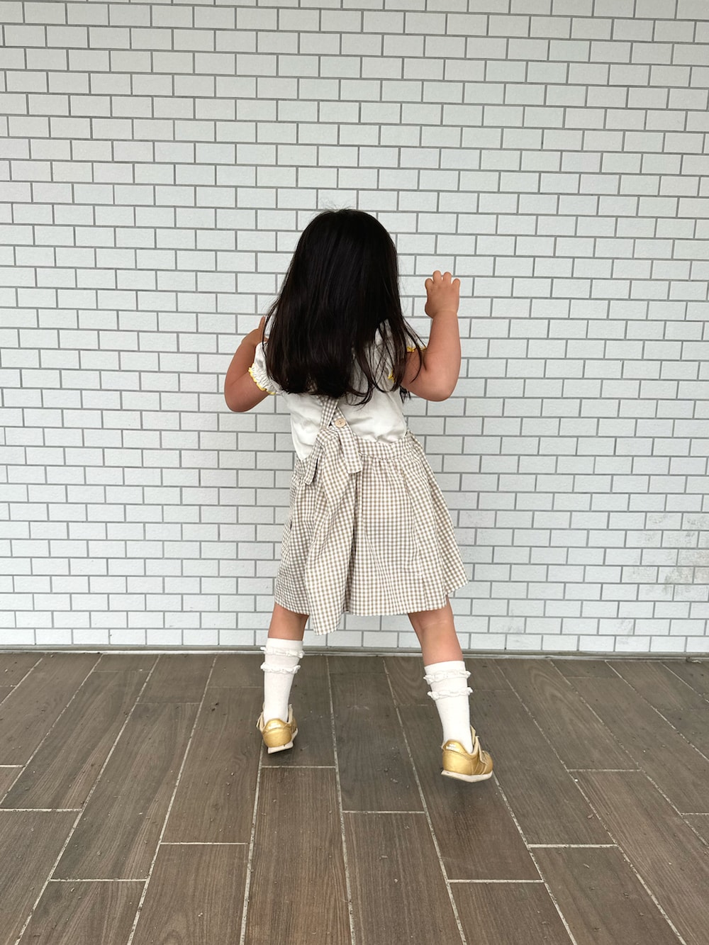 ベージュ系のその他アウター、ゴールド系のスニーカー、ホワイト系のTシャツ/カットソーを着用したキッズの夏コーディネートの4枚目の写真