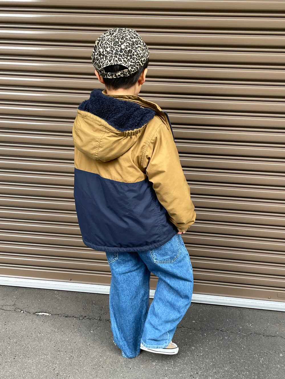 ベージュ系のブルゾン、ピンク系のスウェット、ブルー系のデニムパンツを着用したキッズの冬コーディネートの3枚目の写真