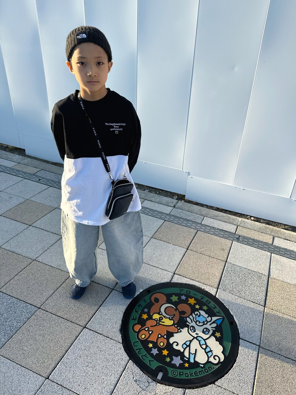 ブルー系のデニムパンツ、ブルー系のスニーカー、ブラック系のTシャツ/カットソーを着用したキッズの秋コーディネートの2枚目の写真