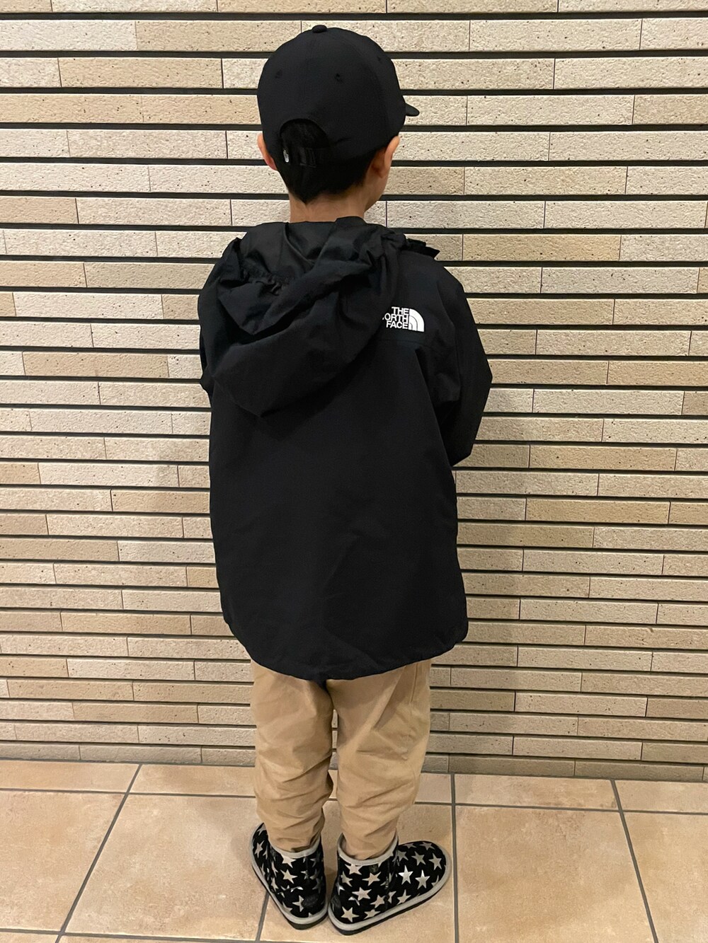 ブラウン系のスウェット、ブラック系のナイロンジャケット、ベージュ系のその他パンツを着用したキッズの秋コーディネートの3枚目の写真