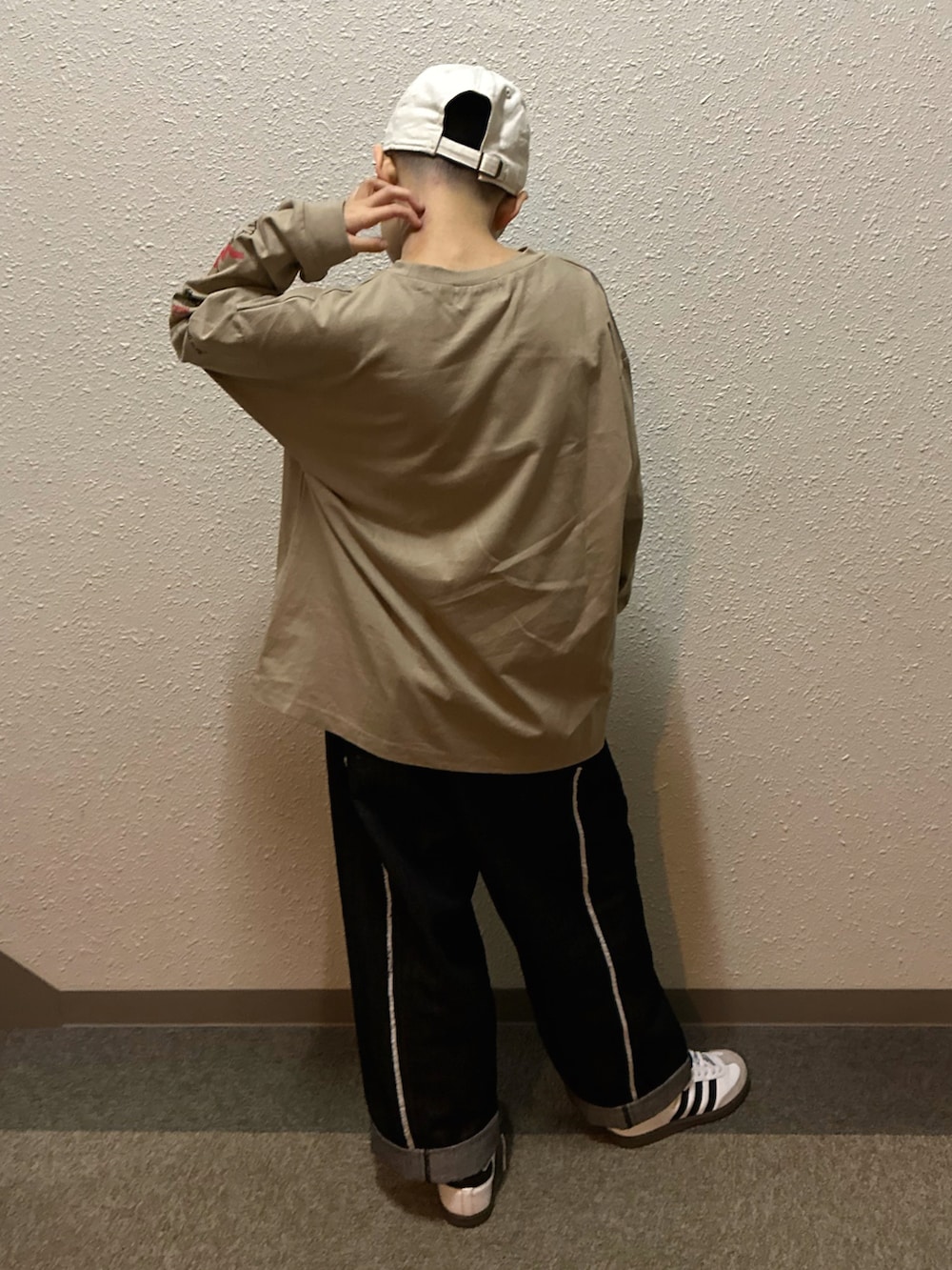 ベージュ系のTシャツ/カットソー、ブラック系のデニムパンツ、ホワイト系のスニーカーを着用したキッズの春コーディネートの3枚目の写真