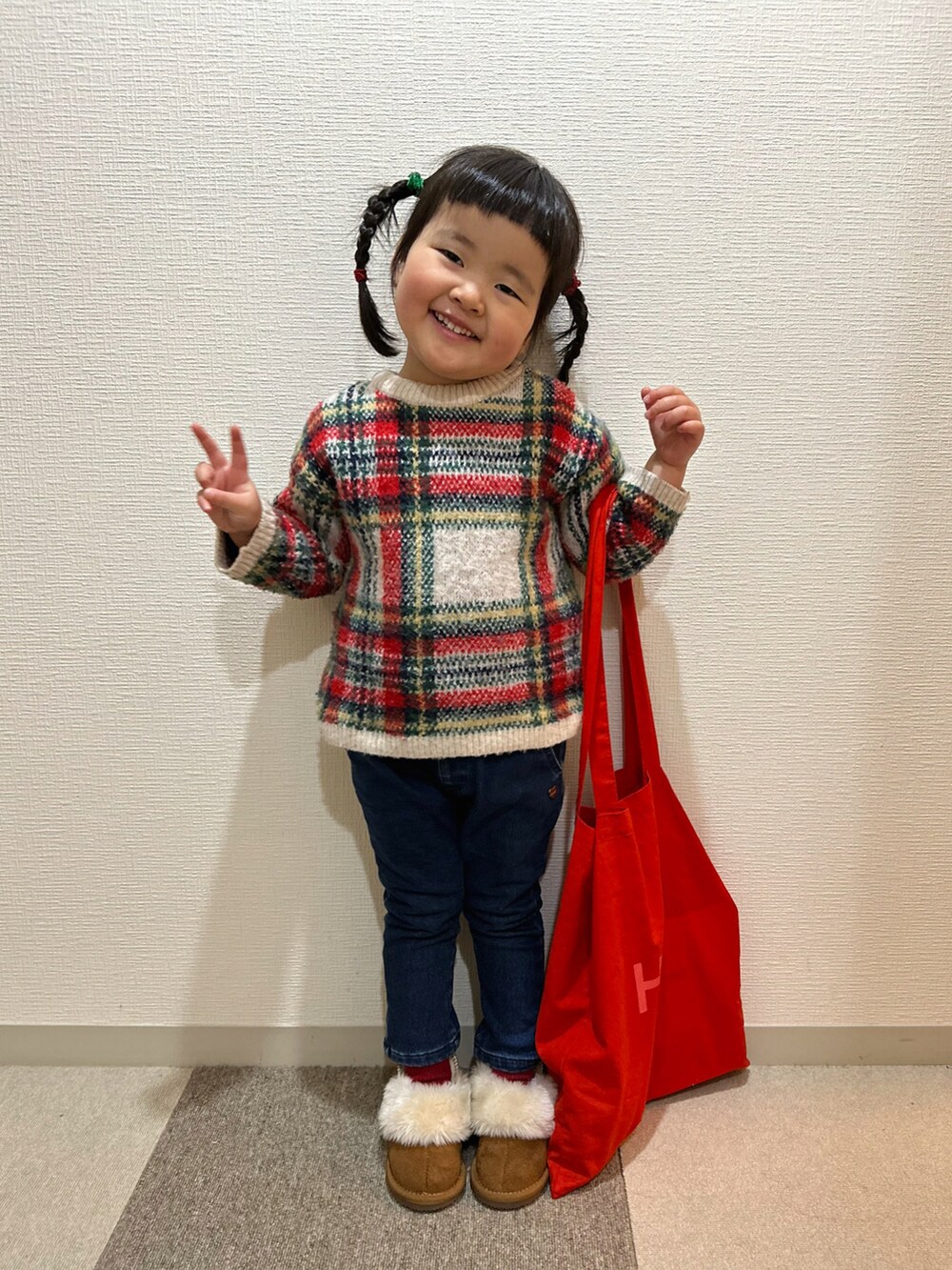 レッド系のニット/セーター、ブルー系のその他パンツ、イエロー系のブーツを着用したキッズの冬コーディネートの4枚目の写真