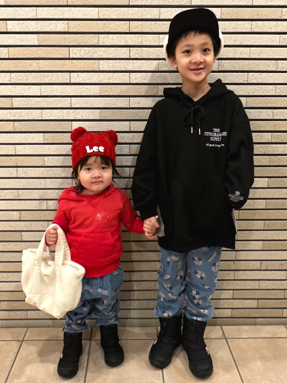 ブラック系のパーカー、ブルー系のデニムパンツ、ブラック系のブーツを着用したキッズの冬コーディネートの3枚目の写真