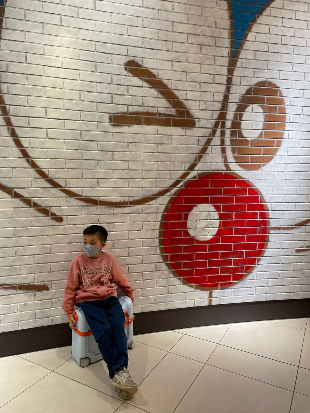 ピンク系のスウェット、ブルー系のデニムパンツ、シルバー系のスニーカーを着用したキッズの冬コーディネートの3枚目の写真