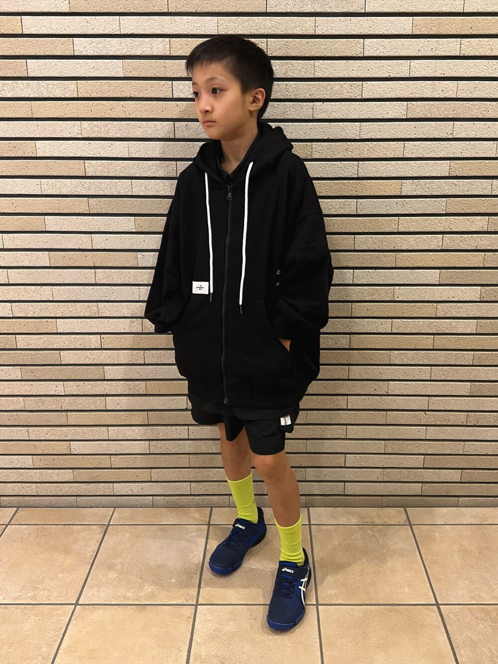 ブラック系のパーカー、ブラック系のパンツ、ブルー系のスニーカーを着用したキッズの秋コーディネートの4枚目の写真