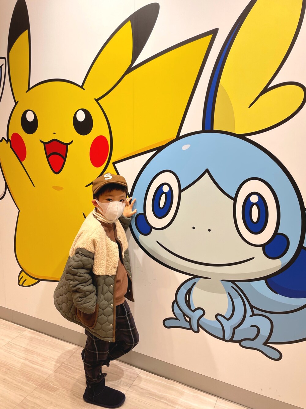 グリーン系のダウンジャケット/コート、ホワイト系のトップス、ブラウン系のアンサンブルを着用したキッズの冬コーディネートの3枚目の写真