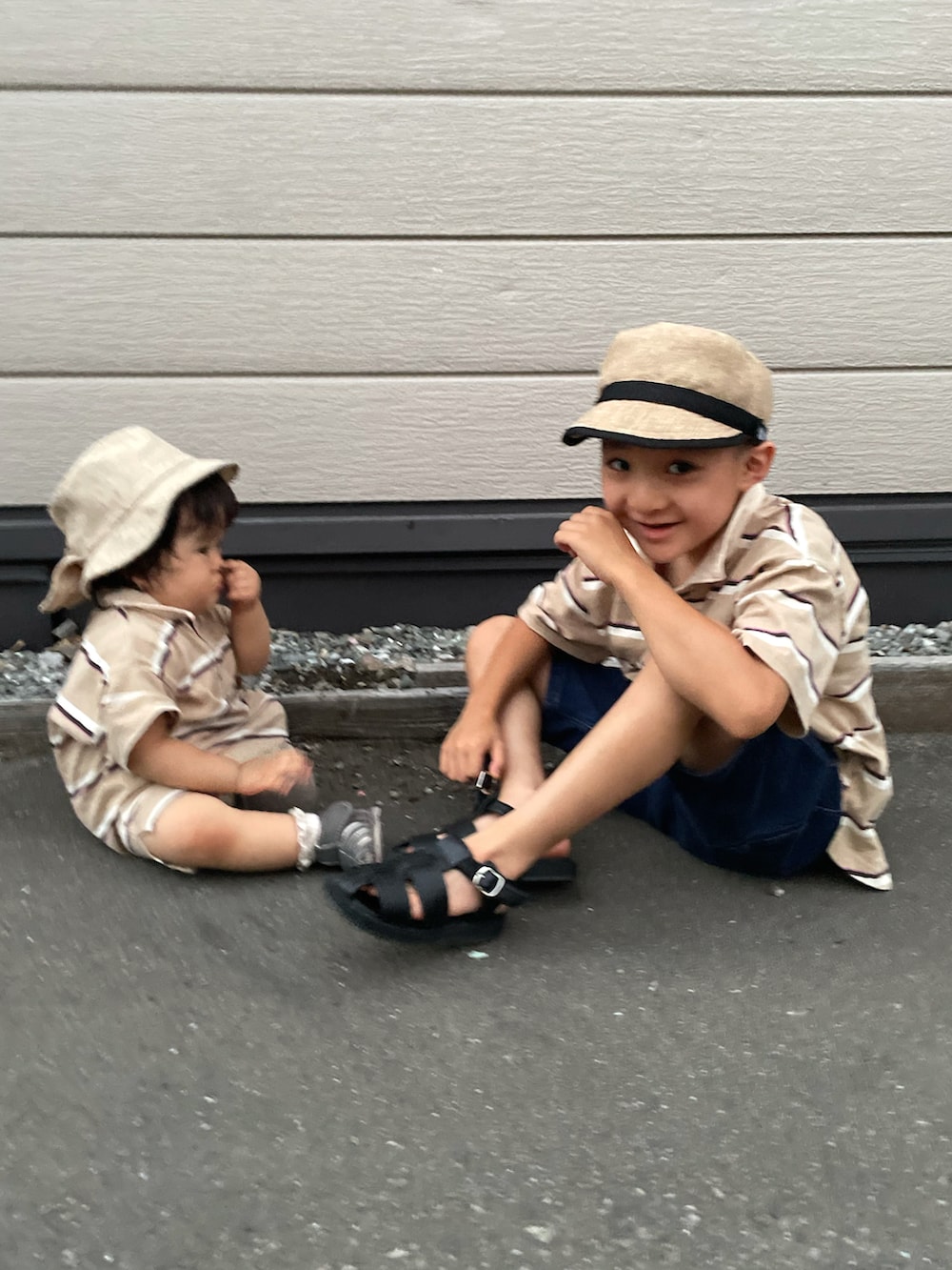 ベージュ系のポロシャツ、ブルー系のデニムパンツ、ブラック系のサンダルを着用したキッズの秋コーディネートの3枚目の写真