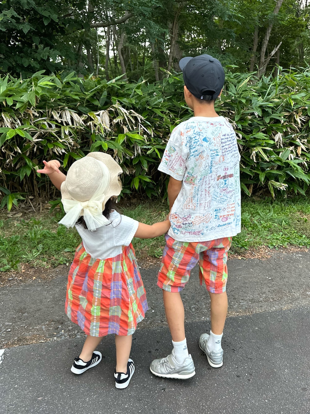 ホワイト系のTシャツ/カットソー、オレンジ系のパンツ、シルバー系のスニーカーを着用したキッズの夏コーディネートの2枚目の写真