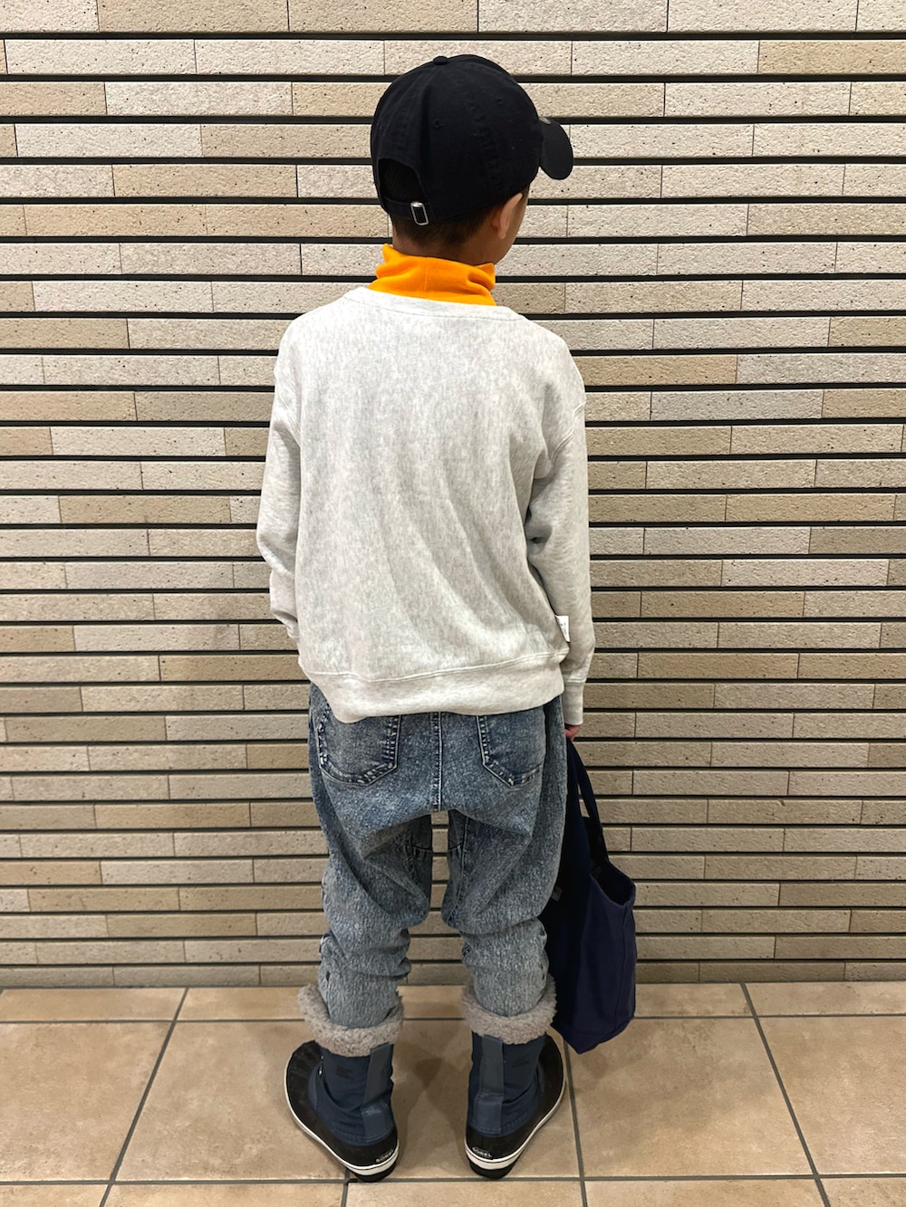 オレンジ系のTシャツ/カットソー、グレー系のスウェット、その他のデニムパンツを着用したキッズの冬コーディネートの4枚目の写真