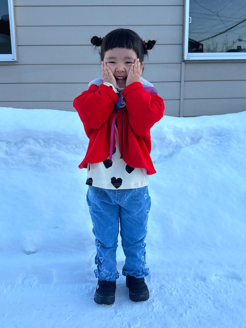ホワイト系のTシャツ/カットソー、レッド系のカーディガン/ボレロ、ブルー系のデニムパンツを着用したキッズの冬コーディネートの2枚目の写真