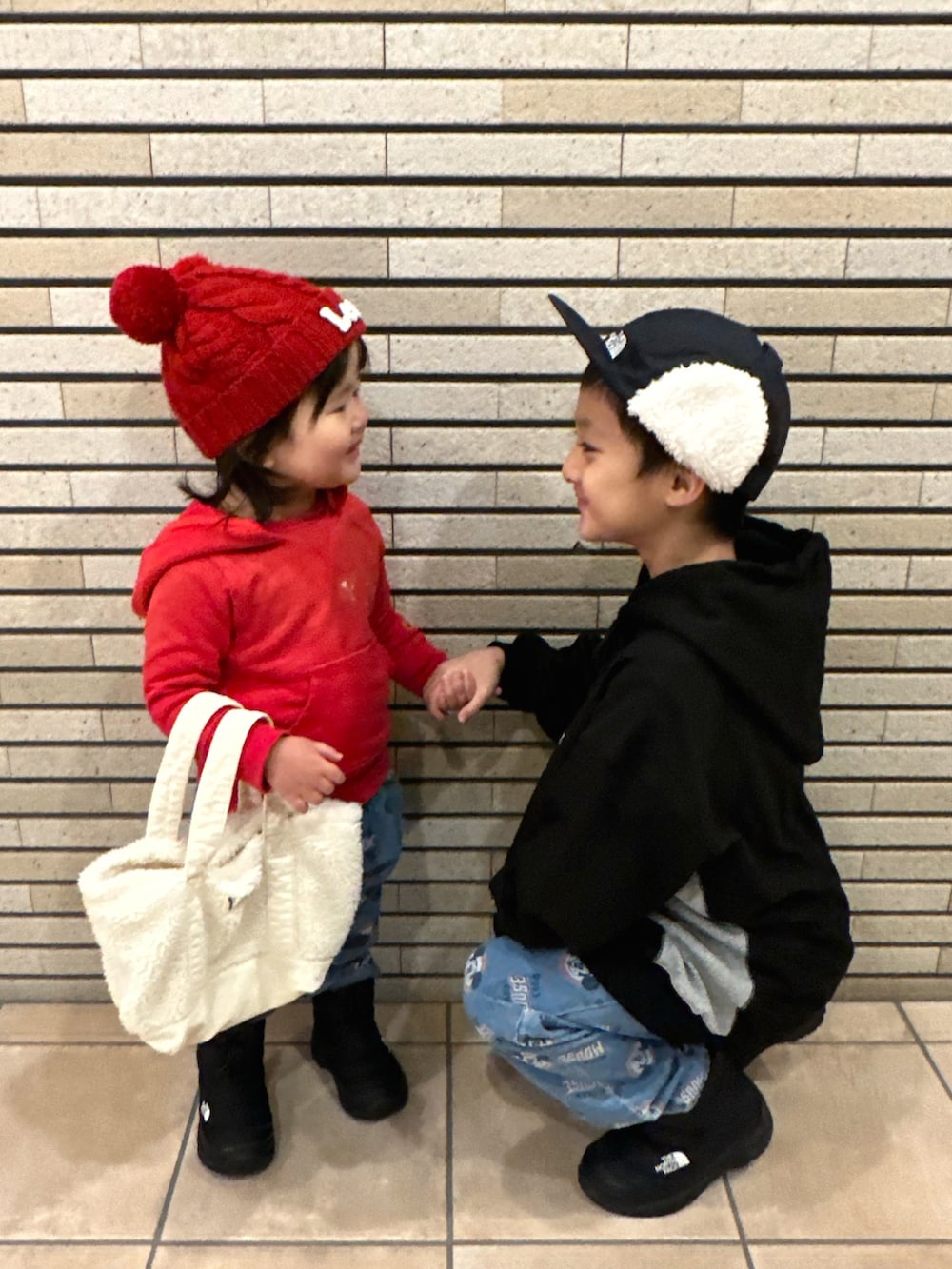 ブラック系のパーカー、ブルー系のデニムパンツ、ブラック系のブーツを着用したキッズの冬コーディネートの2枚目の写真