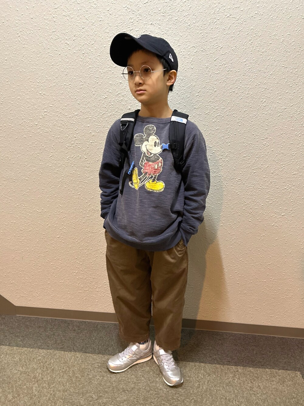 ブルー系のスウェット、ブラック系のバックパック/リュック、ブラウン系のチノパンツを着用したキッズの春コーディネートの2枚目の写真