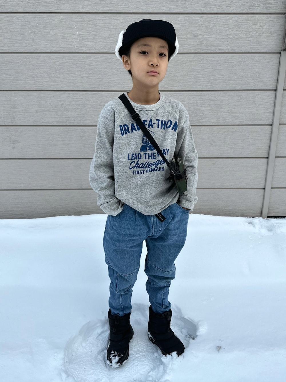 グレー系のスウェット、ブルー系のデニムパンツ、ブラック系のブーツを着用したキッズの秋コーディネートの3枚目の写真
