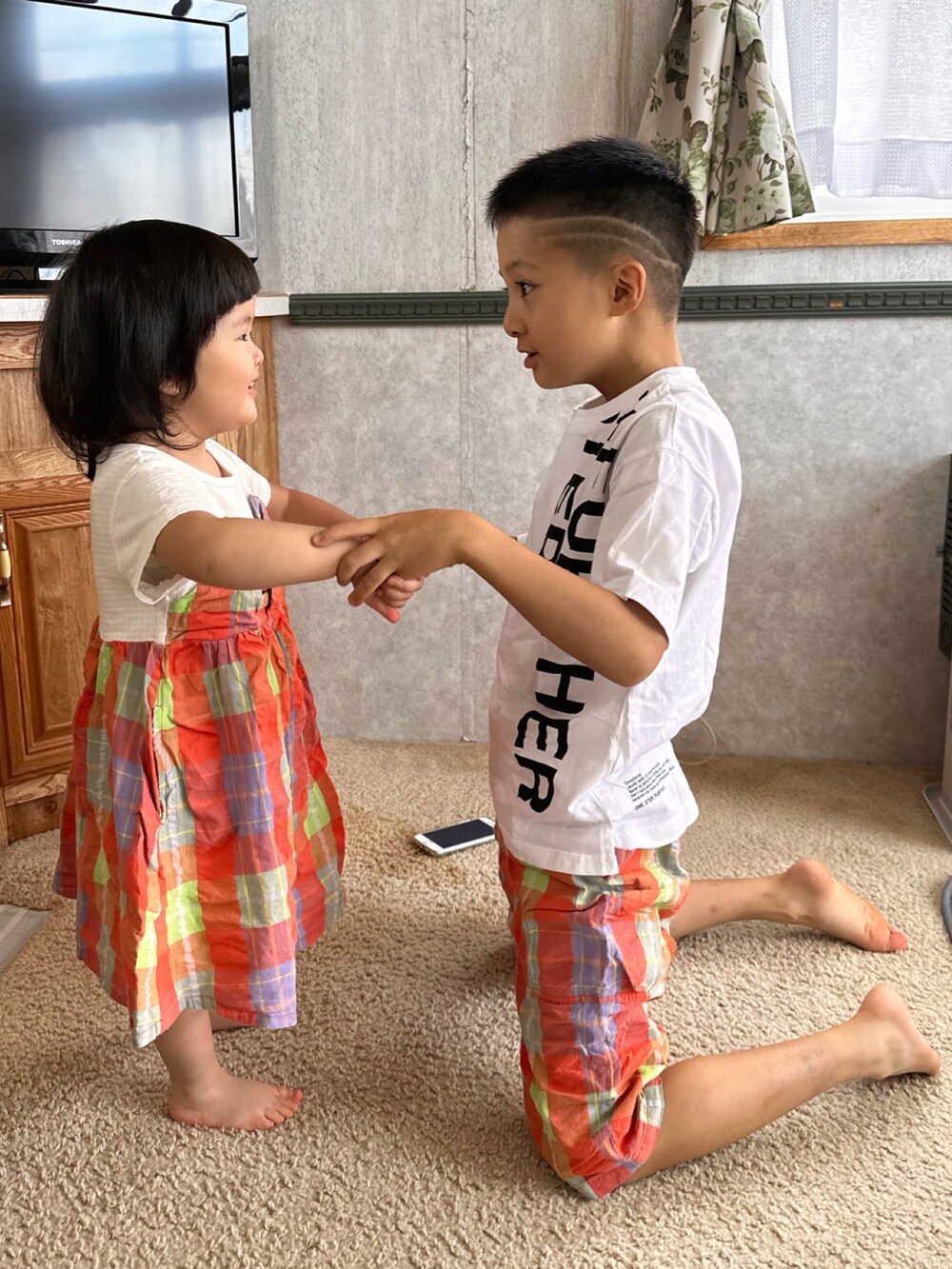 オレンジ系のワンピース/ドレス、ホワイト系のTシャツ/カットソー、オレンジ系のパンツを着用したキッズの秋コーディネートの5枚目の写真