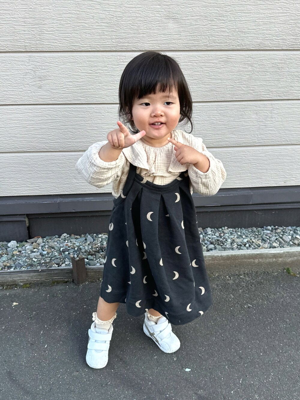 ベージュ系のシャツ/ブラウス、ブラック系のワンピース、ホワイト系のスニーカーを着用したキッズの秋コーディネートの4枚目の写真