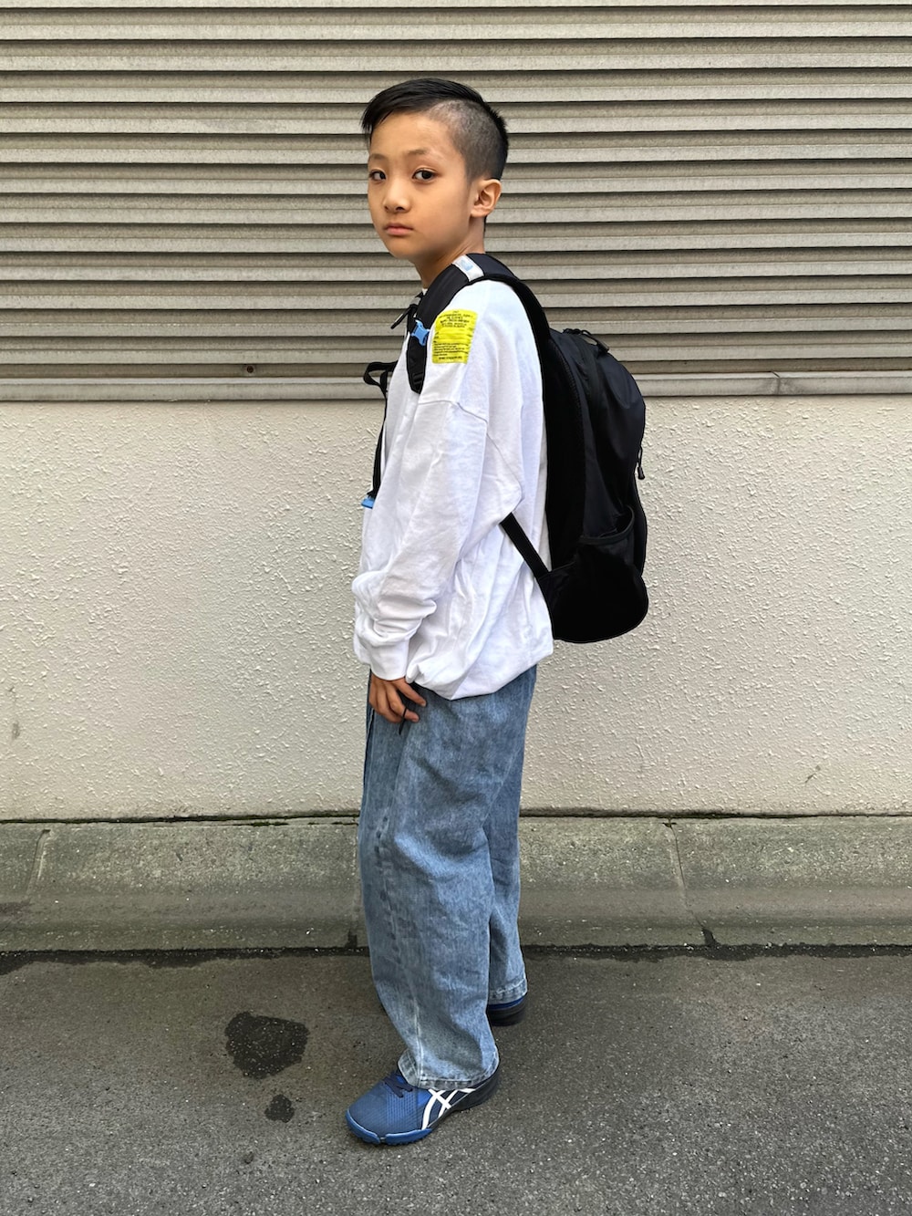 ホワイト系のTシャツ/カットソー、ブルー系のデニムパンツ、ブラック系のバックパック/リュックを着用したキッズの秋コーディネートの3枚目の写真