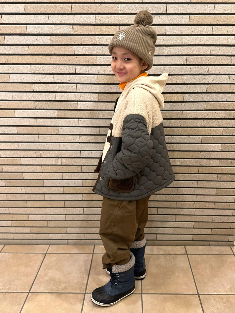 グリーン系のダウンジャケット/コート、ホワイト系のTシャツ/カットソー、オレンジ系のTシャツ/カットソーを着用したキッズの冬コーディネートの3枚目の写真