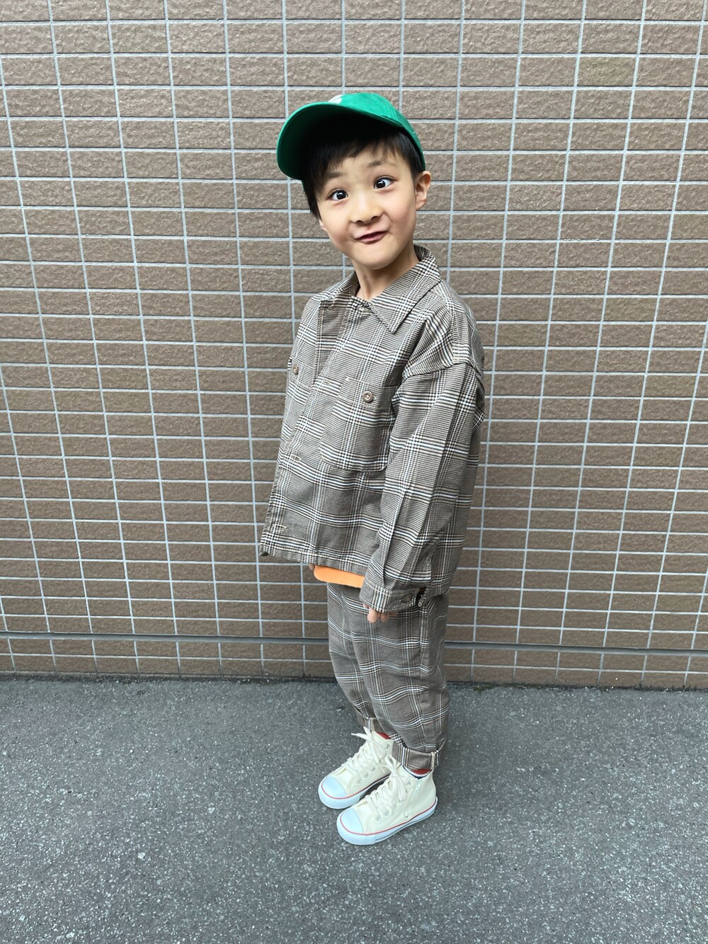 ブラウン系のジャケット/アウター、オレンジ系のスウェット、ブラウン系のパンツを着用したキッズの春コーディネートの4枚目の写真