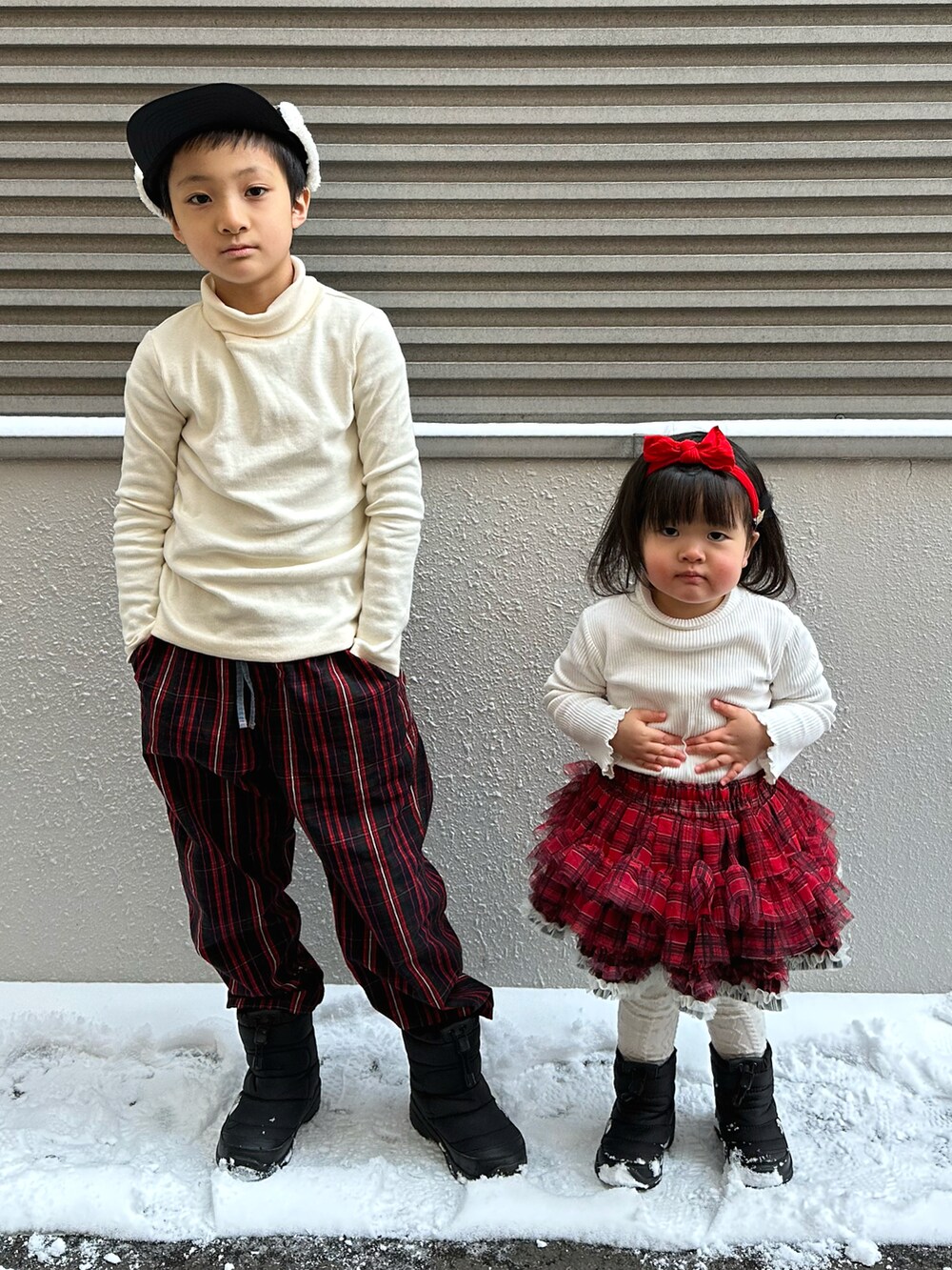 ホワイト系のTシャツ/カットソー、レッド系のその他パンツ、ブラック系のブーツを着用したキッズの冬コーディネートの2枚目の写真