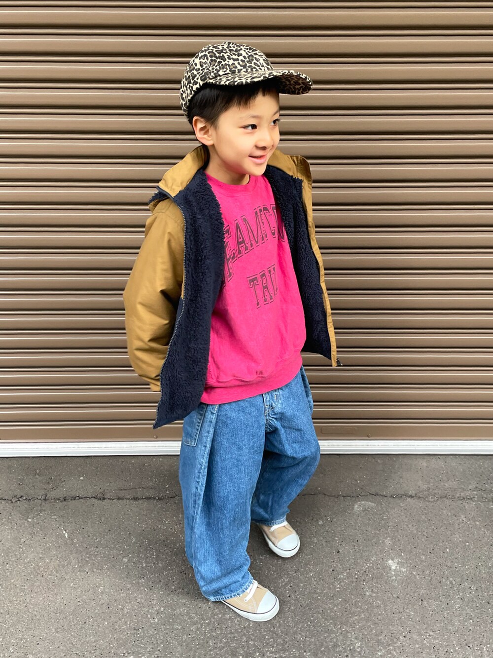 ベージュ系のブルゾン、ピンク系のスウェット、ブルー系のデニムパンツを着用したキッズの冬コーディネートの2枚目の写真