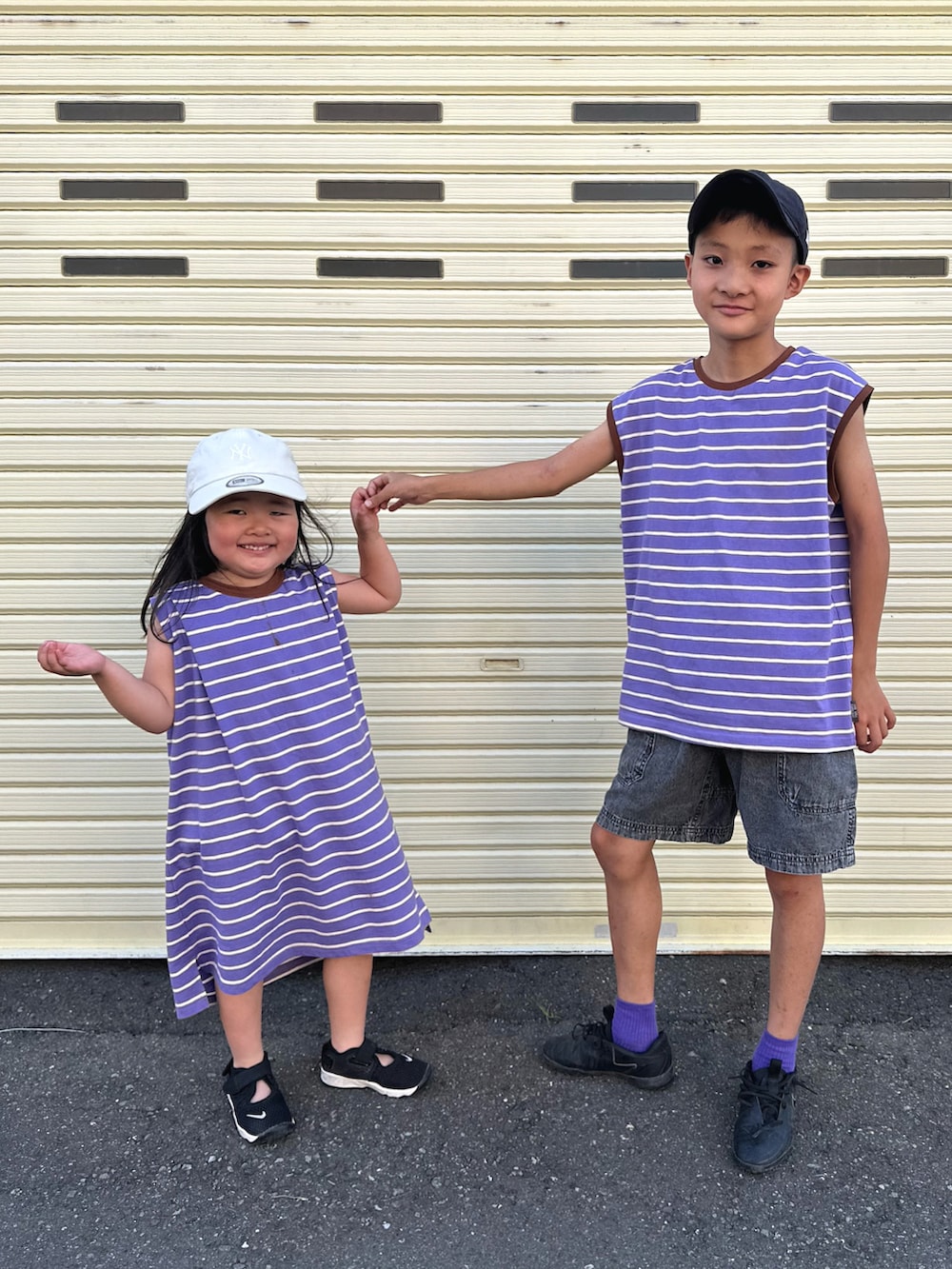 パープル系のTシャツ/カットソー、パープル系のワンピース、ブラック系のデニムパンツを着用したキッズの夏コーディネートの3枚目の写真