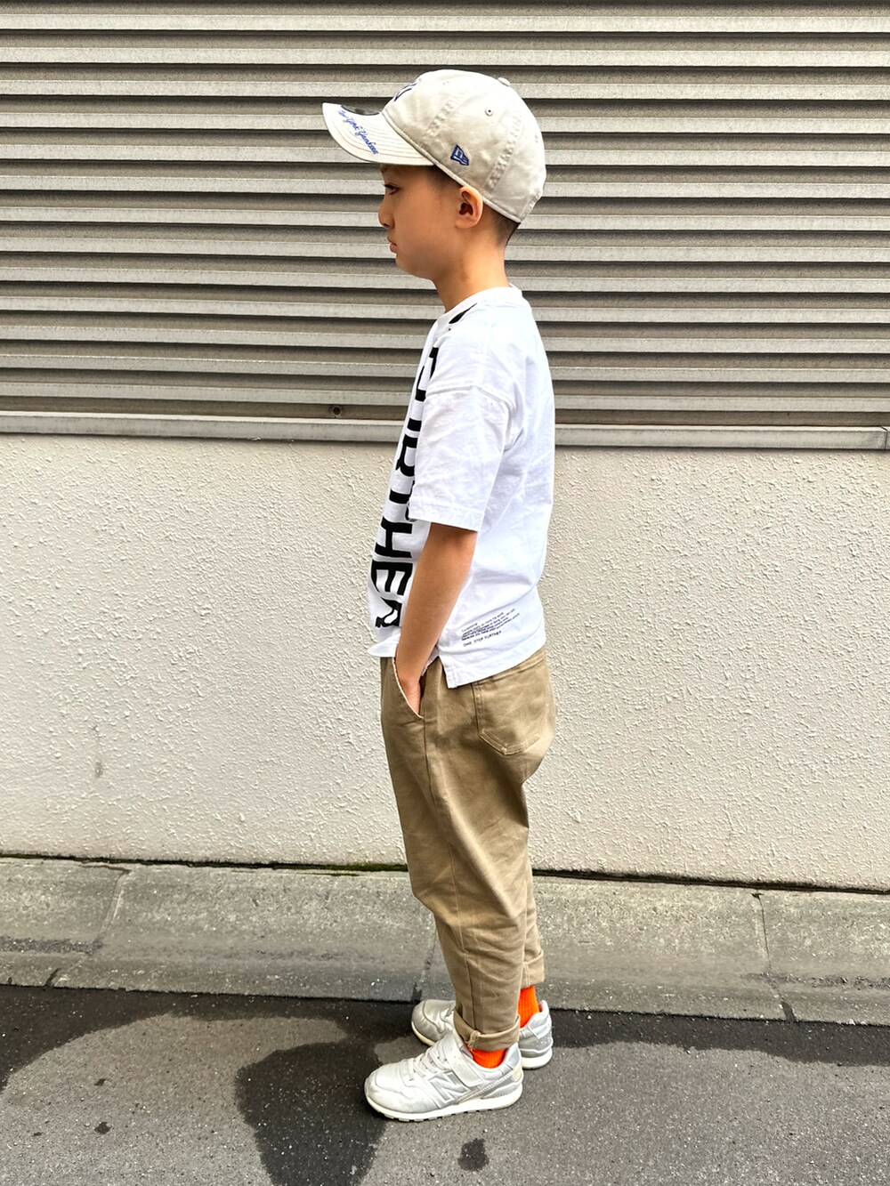 ホワイト系のTシャツ/カットソー、ブラック系のカーディガン/ボレロ、ベージュ系のチノパンツを着用したキッズの春コーディネートの4枚目の写真