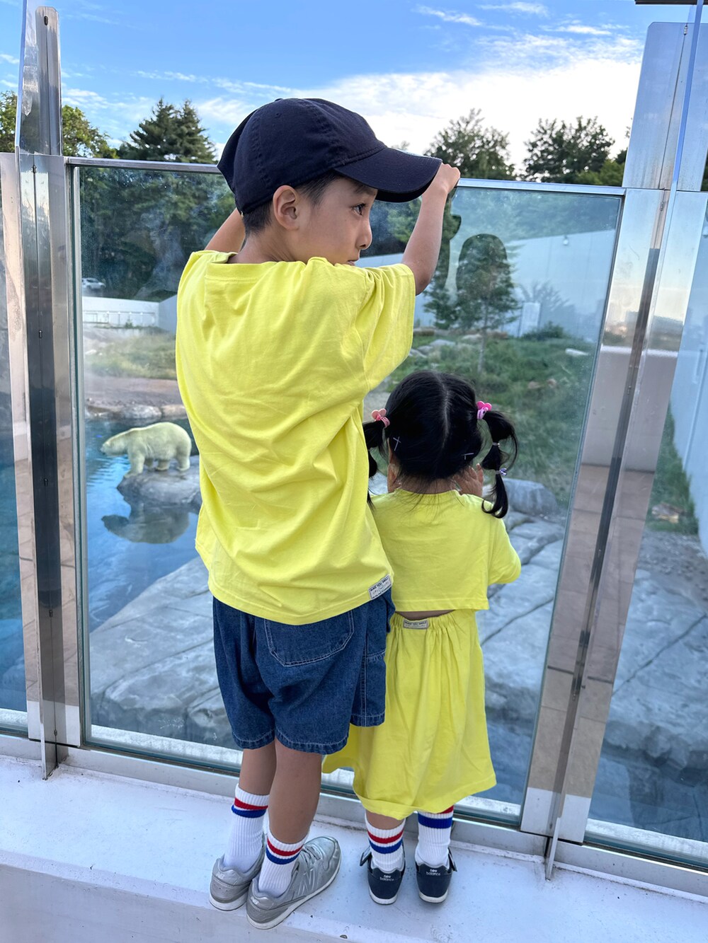 イエロー系のTシャツ/カットソー、ブルー系のデニムパンツ、シルバー系のスニーカーを着用したキッズの秋コーディネートの3枚目の写真