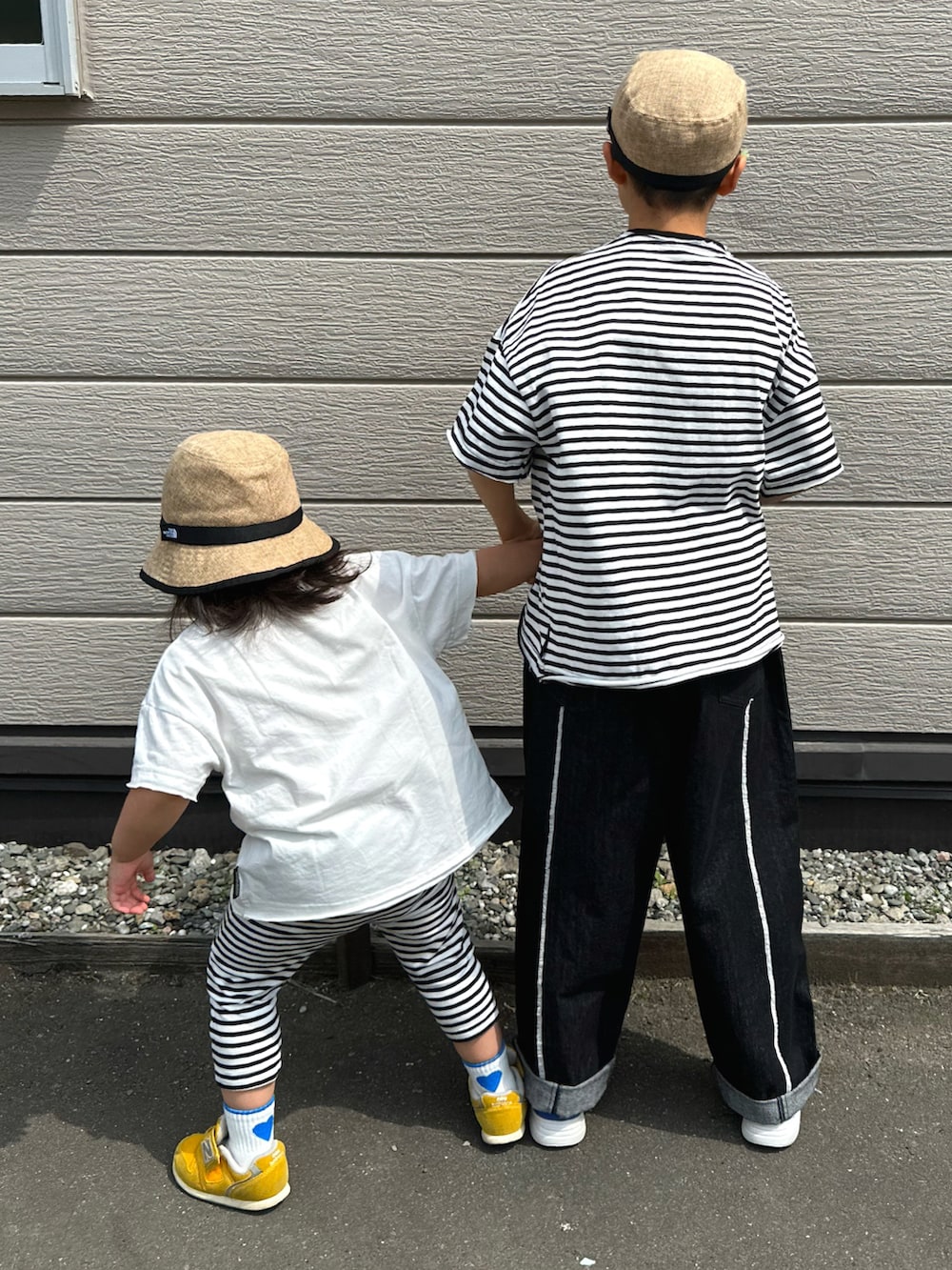 ブルー系のスニーカー、イエロー系のスニーカー、ブラック系のTシャツ/カットソーを着用したキッズの秋コーディネートの3枚目の写真