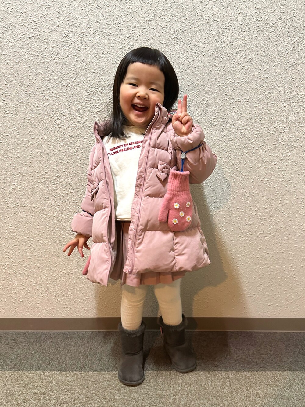 ピンク系のダウンジャケット/コート、ホワイト系のスウェット、ピンク系のその他パンツを着用したキッズの冬コーディネートの3枚目の写真