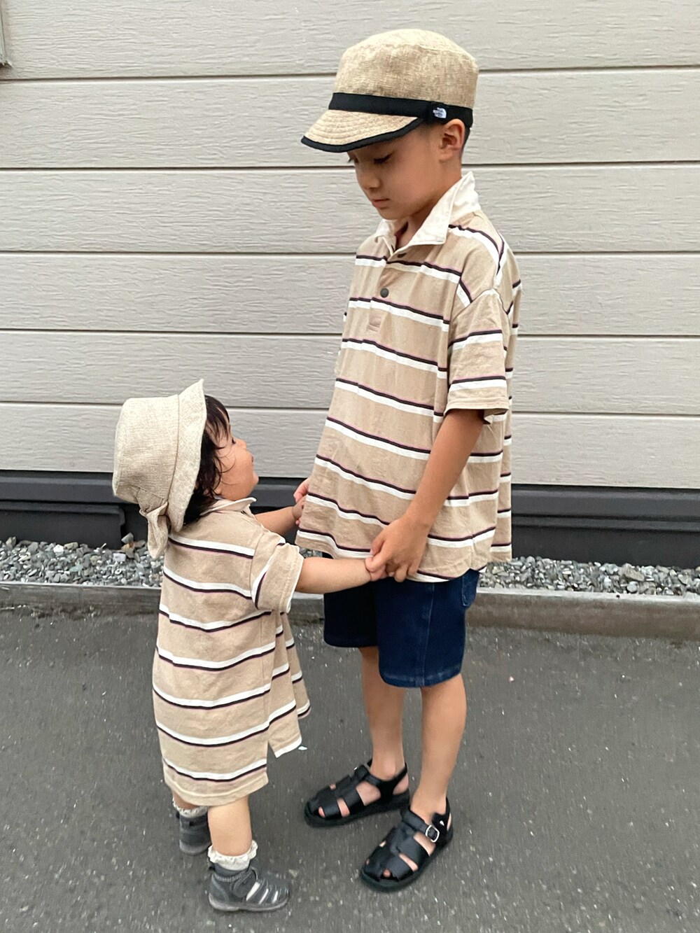 ベージュ系のポロシャツ、ブルー系のデニムパンツ、ブラック系のサンダルを着用したキッズの秋コーディネートの4枚目の写真