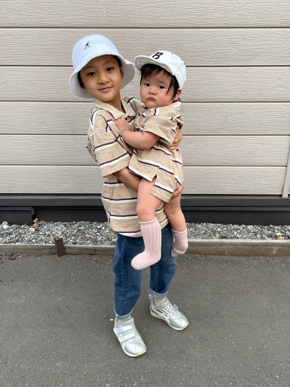 ベージュ系のポロシャツ、ブルー系のデニムパンツ、シルバー系のスニーカーを着用したキッズの春コーディネートの3枚目の写真