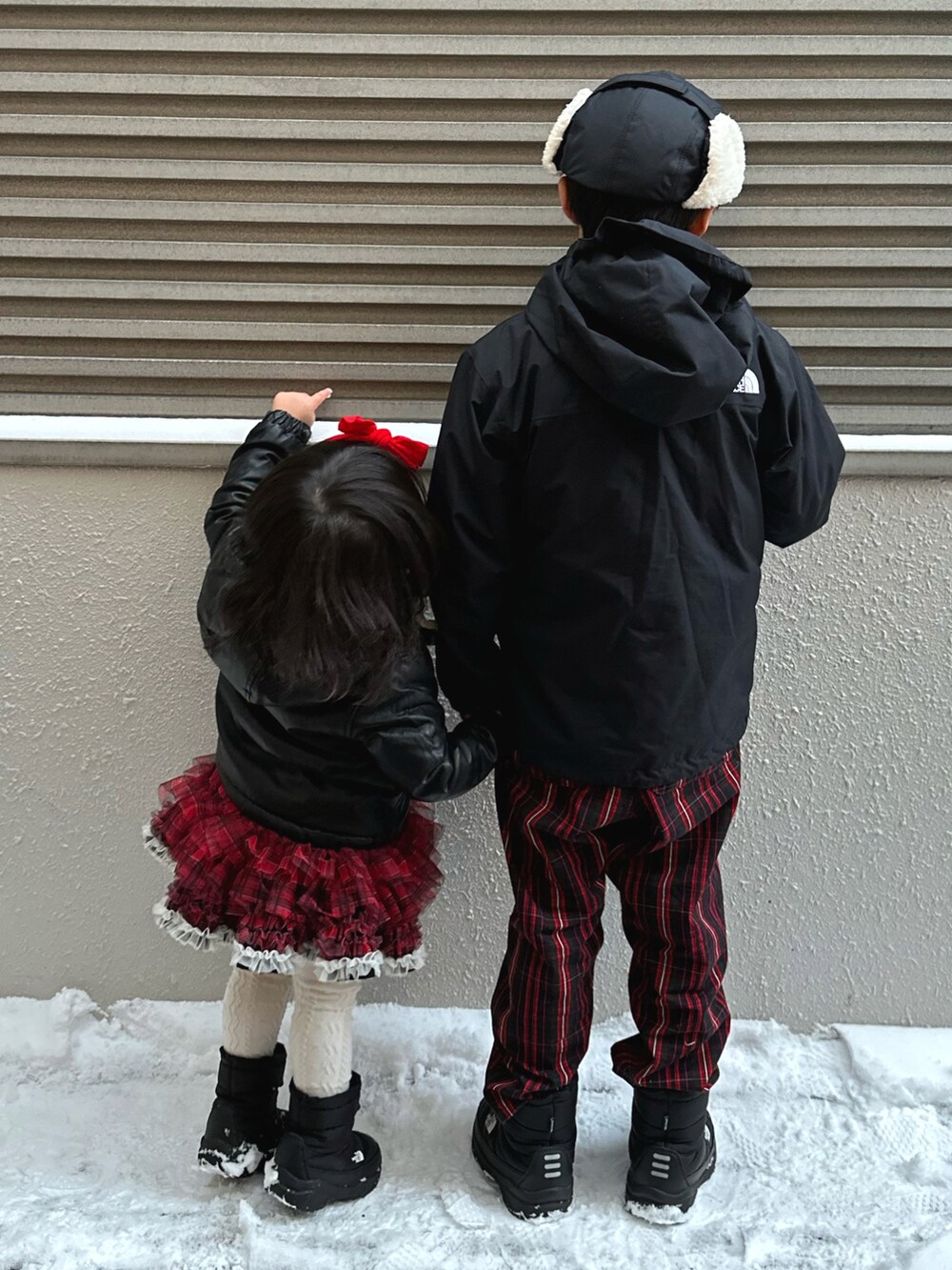 ブラック系のナイロンジャケット、ブルー系のその他アウター、レッド系のその他パンツを着用したキッズの冬コーディネートの3枚目の写真