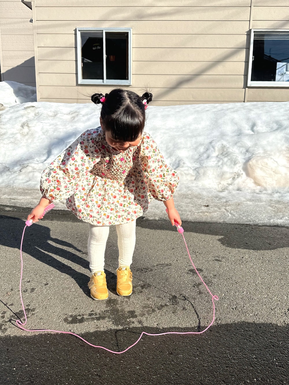 ピンク系のチュニック、ブルー系のデニムパンツ、ゴールド系のスニーカーを着用したキッズの春コーディネートの2枚目の写真