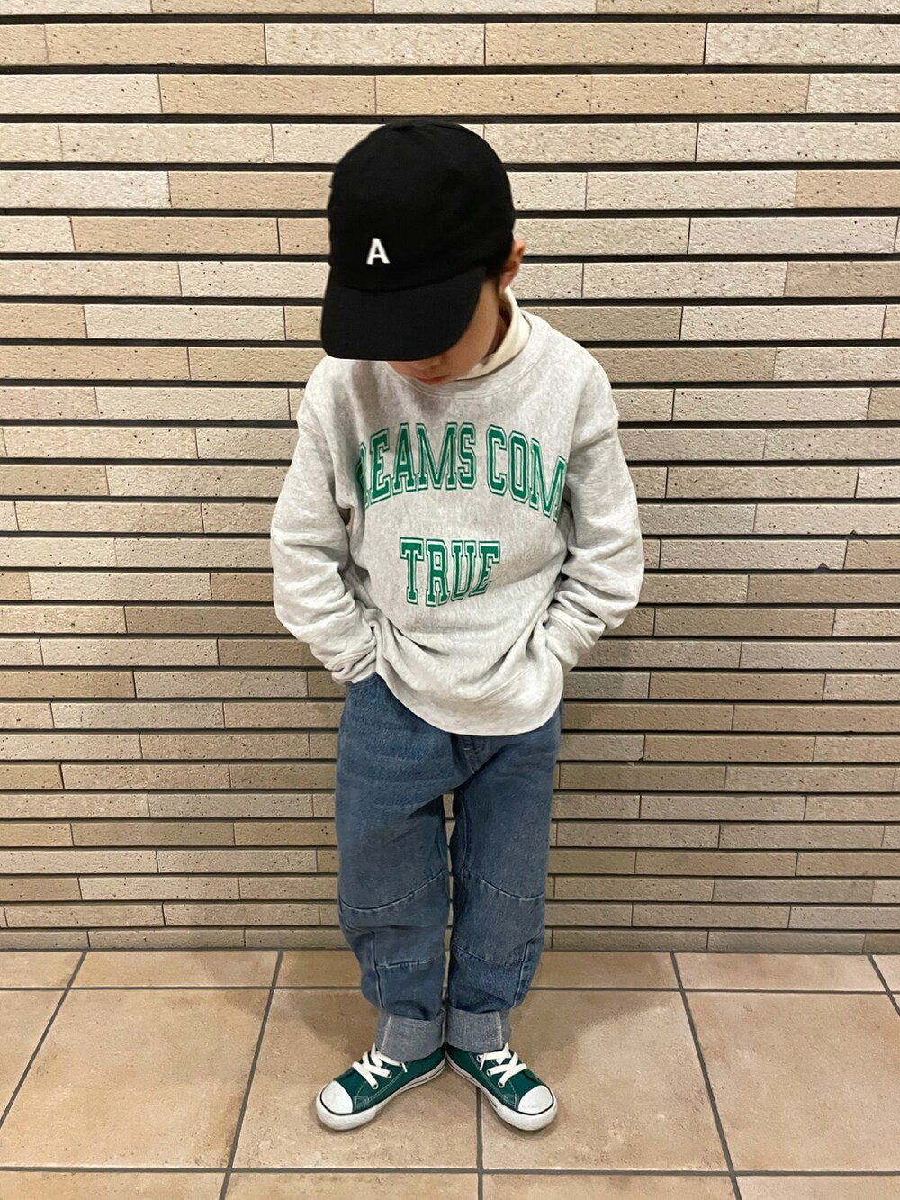 グレー系のスウェット、ホワイト系のトップス、ブルー系のデニムパンツを着用したキッズの冬コーディネートの2枚目の写真