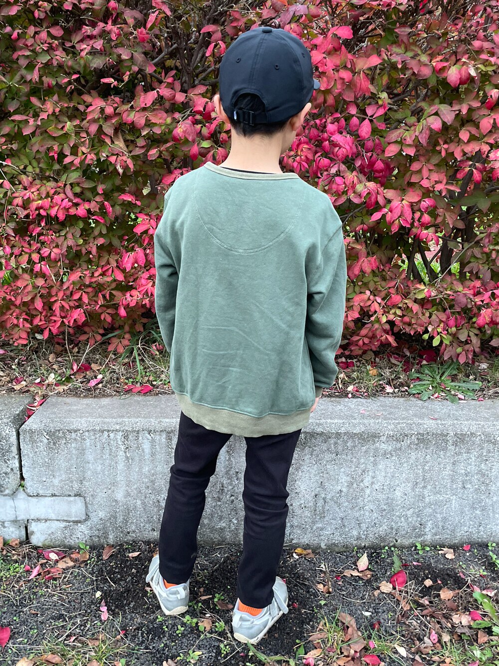 グリーン系のカーディガン/ボレロ、ブラック系のTシャツ/カットソー、ブラック系のパンツを着用したキッズの秋コーディネートの3枚目の写真