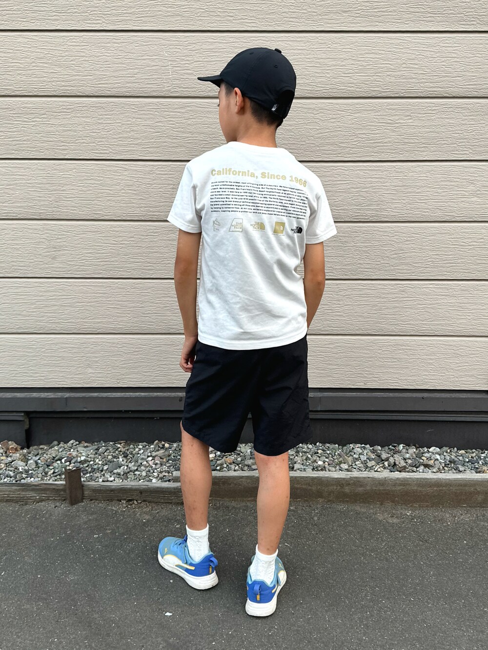 ブラック系のその他パンツ、ブルー系のスニーカー、ホワイト系のTシャツ/カットソーを着用したキッズの秋コーディネートの2枚目の写真