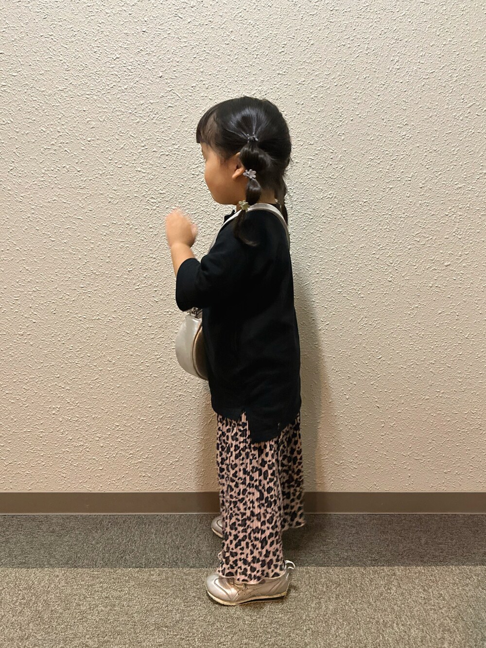 ブラック系のワンピース、ブラウン系のパンツ、シルバー系のショルダーバッグを着用したキッズの秋コーディネートの2枚目の写真