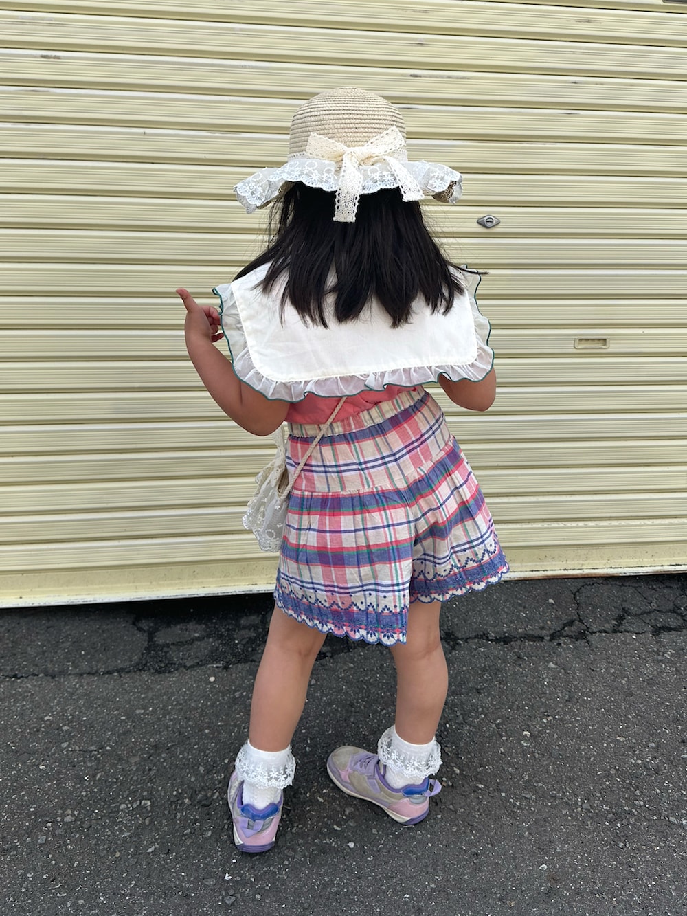 パープル系のスニーカー、ピンク系のTシャツ/カットソー、ホワイト系のショルダーバッグを着用したキッズの夏コーディネートの4枚目の写真