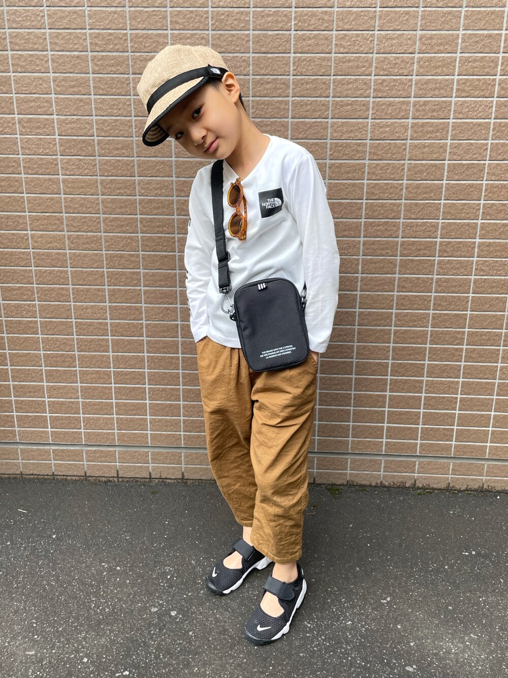 ホワイト系のTシャツ/カットソー、イエロー系のその他パンツ、ブラック系のスニーカーを着用したキッズの春コーディネートの2枚目の写真