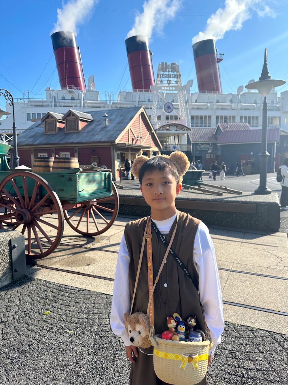 ブルー系のスニーカー、ブラウン系のベスト、ホワイト系のTシャツ/カットソーを着用したキッズの夏コーディネートの2枚目の写真