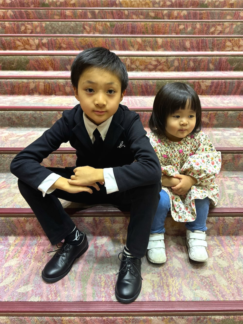 ブラック系のテーラードジャケット、ホワイト系のビジネスシャツ、ブラック系のネクタイを着用したキッズの秋コーディネートの2枚目の写真