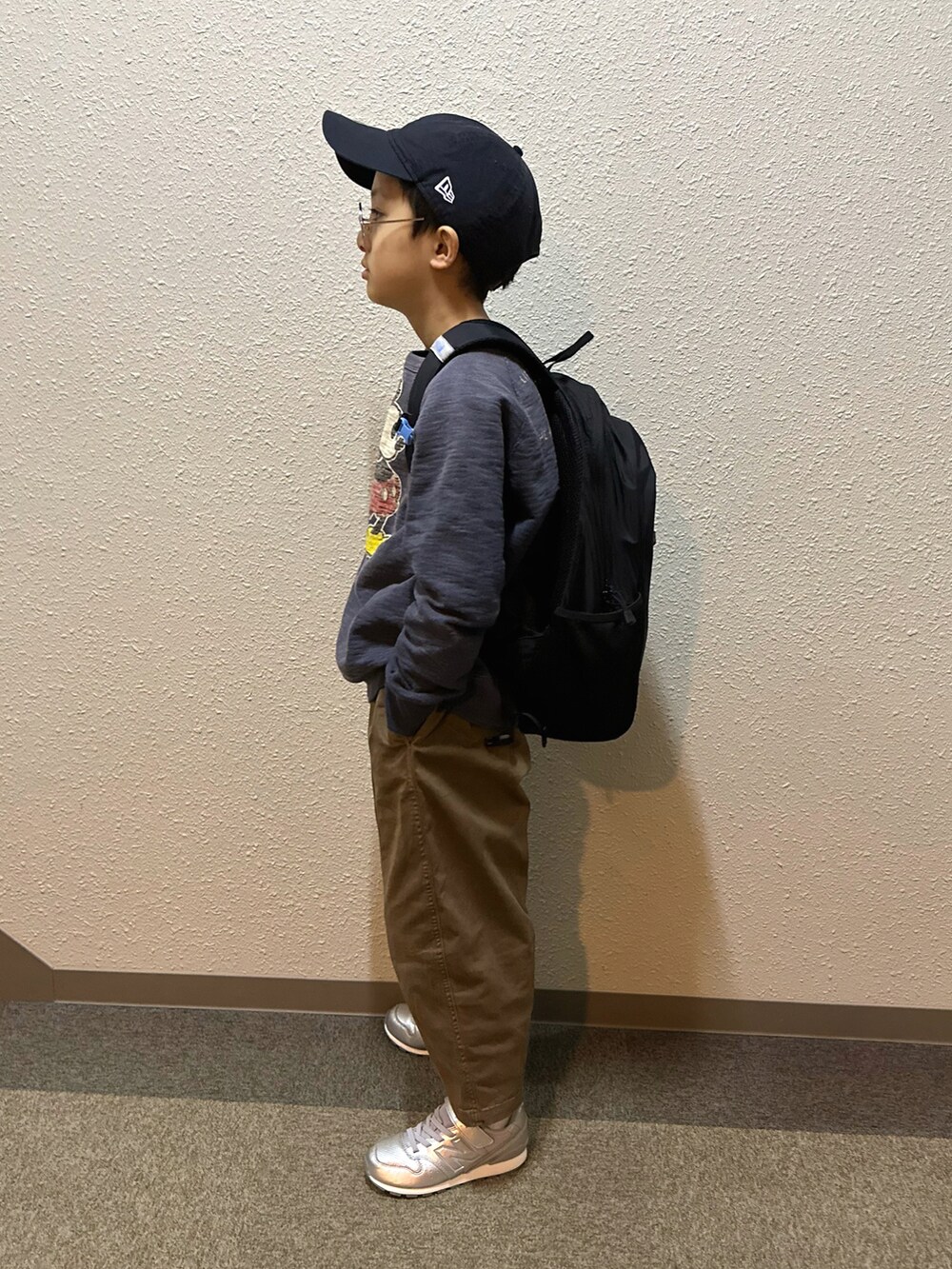 ブルー系のスウェット、ブラック系のバックパック/リュック、ブラウン系のチノパンツを着用したキッズの春コーディネートの3枚目の写真