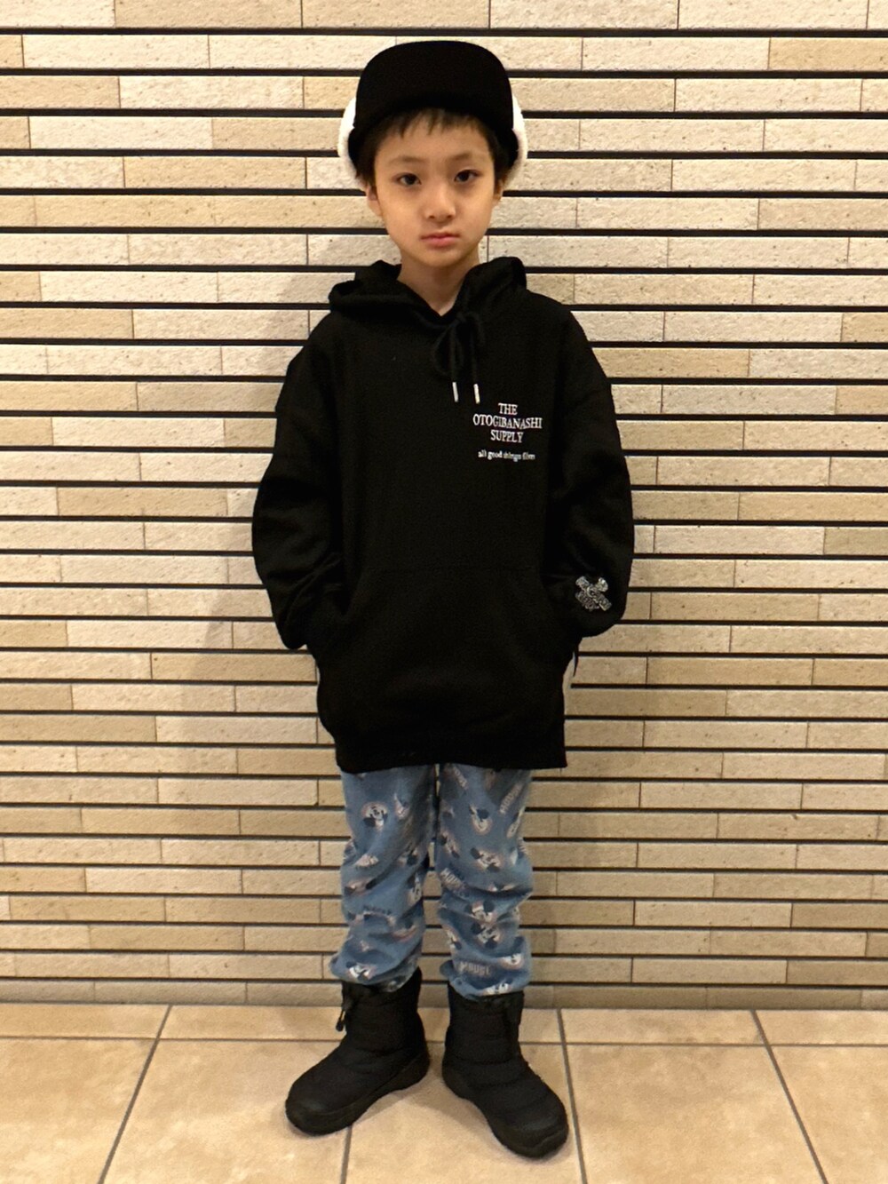 ブラック系のパーカー、ブルー系のデニムパンツ、ブラック系のブーツを着用したキッズの冬コーディネートの4枚目の写真